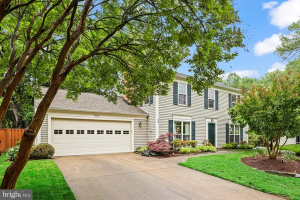 a view of an house with backyard and a tree