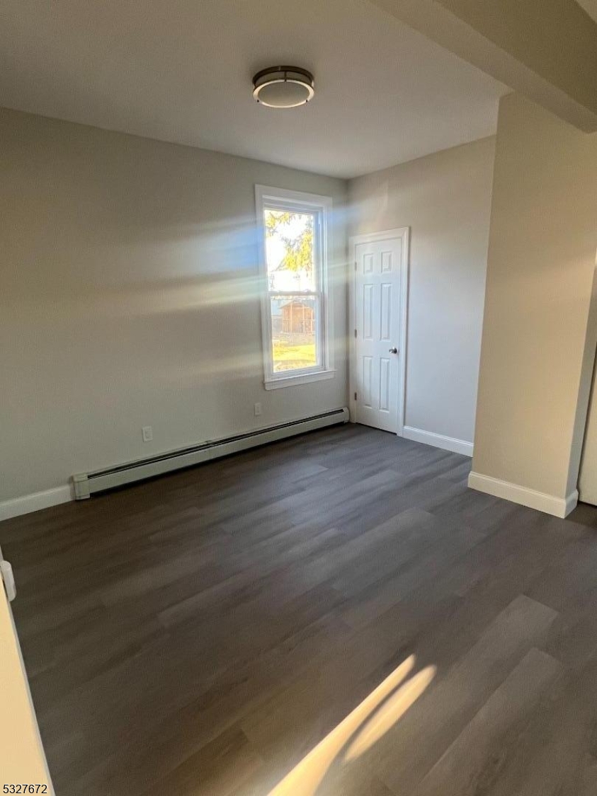 149 Atlantic Street Paterson, NJ 07503 - Photo 3 of 11 an empty room with wooden floor and windows