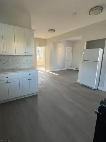 an empty room with wooden floor and cabinet