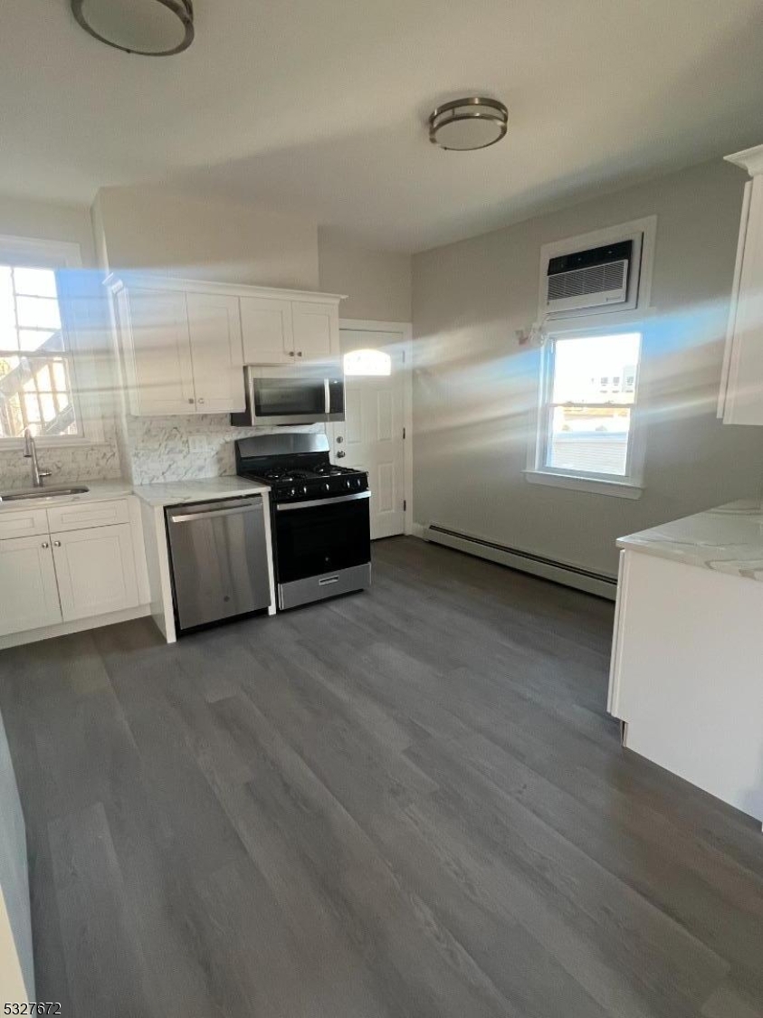 149 Atlantic Street Paterson, NJ 07503 - Photo 5 of 11 a kitchen with stainless steel appliances granite countertop a stove and a refrigerator