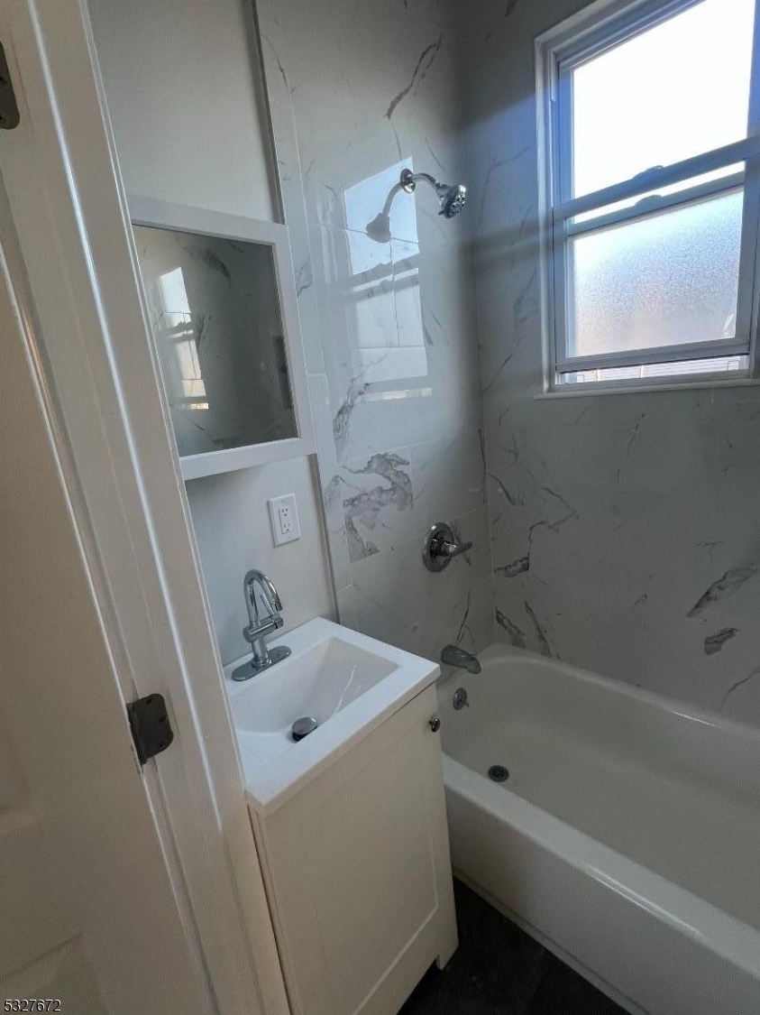 149 Atlantic Street Paterson, NJ 07503 - Photo 10 of 11 a bathroom with a tub sink and mirror