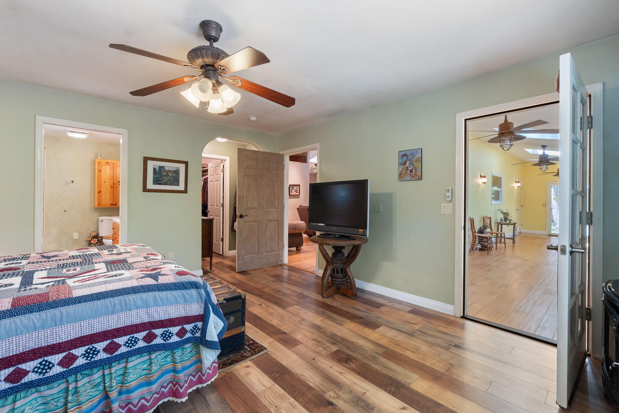 30303 Oak Run To Fern Road Whitmore, CA 96096 - Photo 23 of 75 a bedroom with a bed a chandelier and a flat screen tv