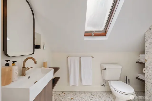 a bathroom with a toilet sink and mirror