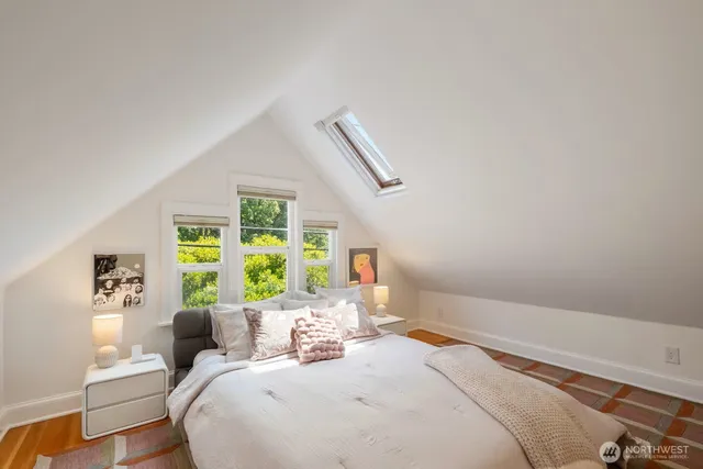 a bedroom with a bed window and wooden floor