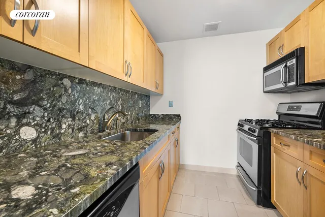 a kitchen with stainless steel appliances granite countertop a sink and a stove