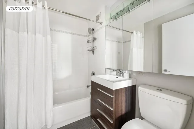 a bathroom with a sink toilet vanity and shower