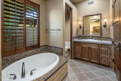 a bathroom with a granite countertop sink a mirror and a shower