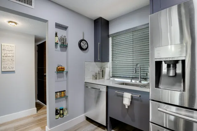 a kitchen with stainless steel appliances granite countertop a refrigerator and a stove