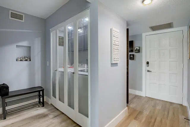 a view of a hallway with wooden floor and staircase