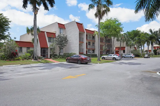 a row of palm trees in front of a house