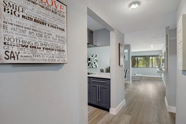 a kitchen with granite countertop white cabinets and wooden floor