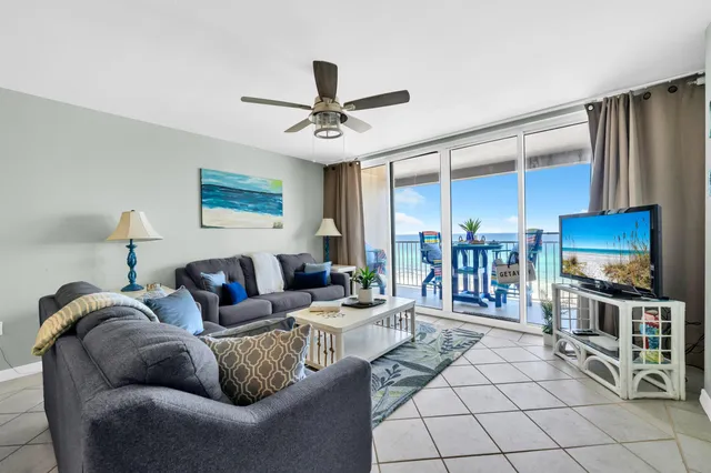 a living room with furniture a flat screen tv and a table
