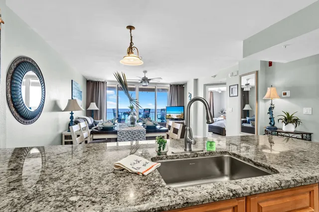 a kitchen with a stove a sink and a dining table with granite countertop
