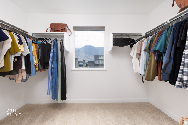 1654 South 730 West Provo, UT 84601 - Photo 21 of 33 Walk-in closet featuring carpet flooring, crisp white walls, ample built-in shelving and hanging rods, and a window providing natural light