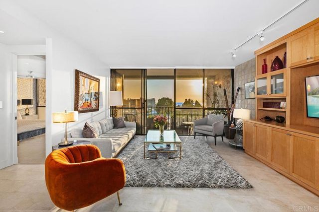 a living room with furniture and a floor to ceiling window