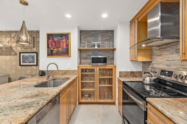 a kitchen with stainless steel appliances granite countertop a sink stove and cabinets