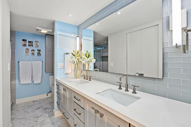 a en suite bathroom with a double vanity sink and a mirror