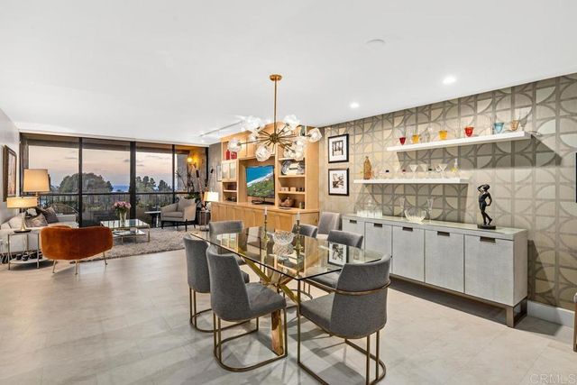 a kitchen with stainless steel appliances granite countertop a stove top oven a dining table and chairs with wooden floor