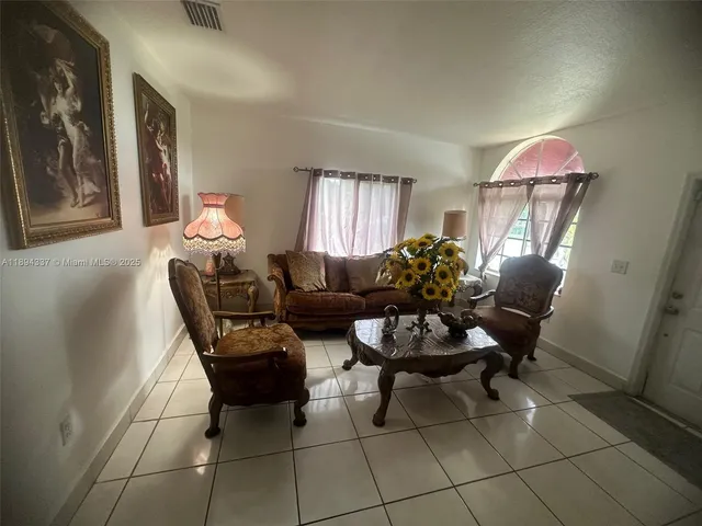 a living room with furniture and a potted plant