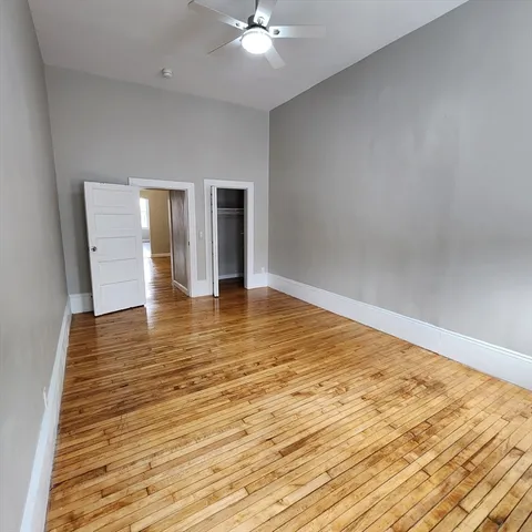 a view of empty room with wooden floor