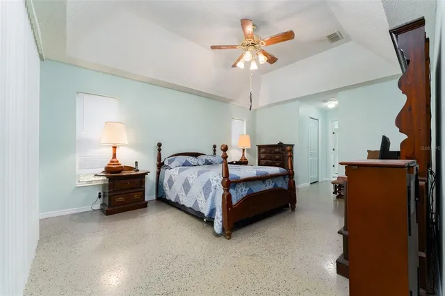 an empty room with windows and fan