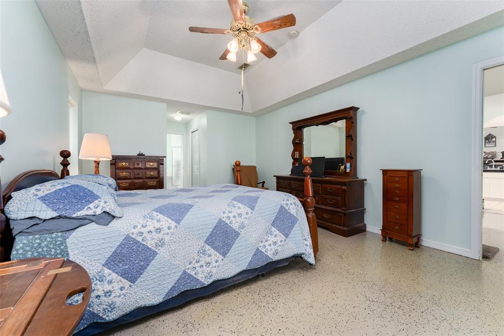 5142 South Louise Point Homosassa, FL 34446 - Photo 32 of 55 a bedroom with a bed dresser and a chandelier