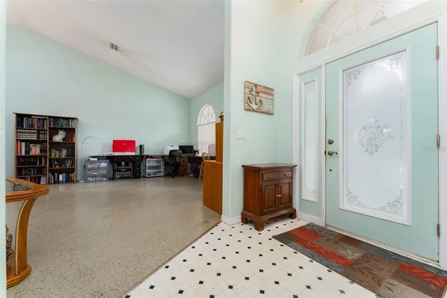 a living room with furniture kitchen view and a chandelier