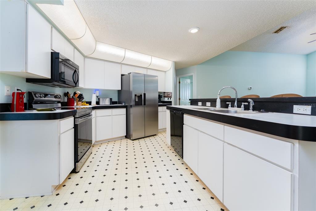 5142 South Louise Point Homosassa, FL 34446 - Photo 51 of 55 a kitchen with stainless steel appliances a sink a stove a microwave a sink and cabinets