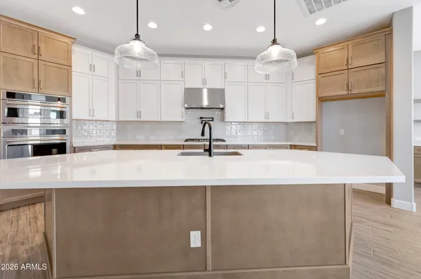 a kitchen with kitchen island a sink stainless steel appliances and cabinets