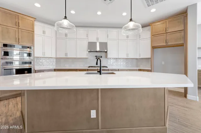 a kitchen with kitchen island a sink stainless steel appliances and cabinets