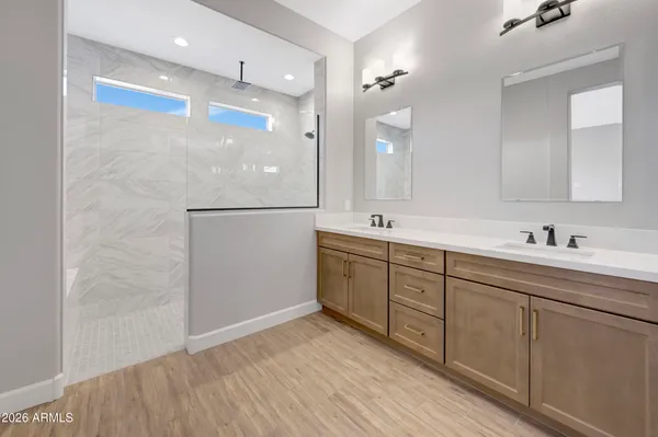 a bathroom with a double vanity sink a mirror and shower