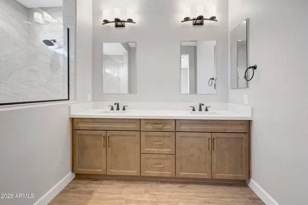 a spacious bathroom with a double vanity sink a mirror and a shower