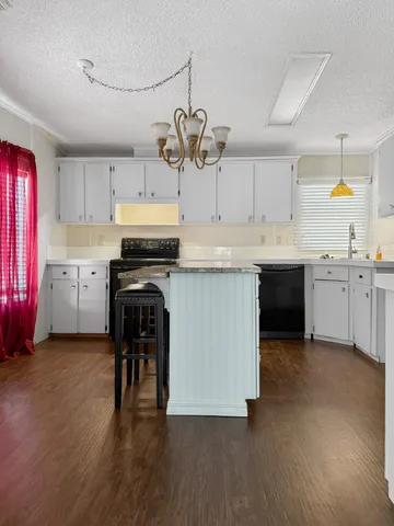 a kitchen with stainless steel appliances kitchen island granite countertop a stove and a refrigerator