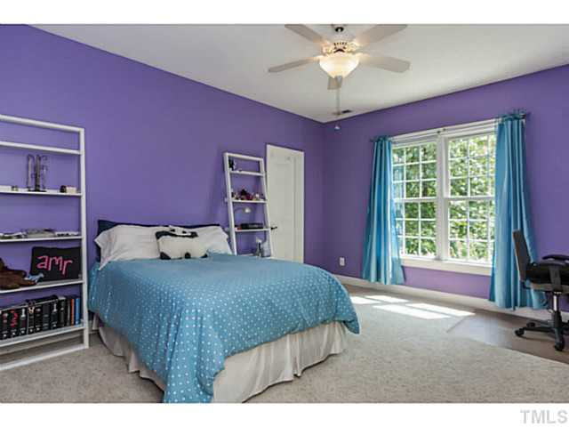 1101 Tacketts Pond Drive Raleigh, NC 27614 - Photo 17 of 25 a bedroom with a bed and a chandelier