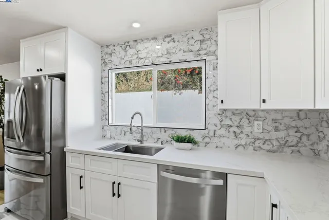 a kitchen with white cabinets and white appliances