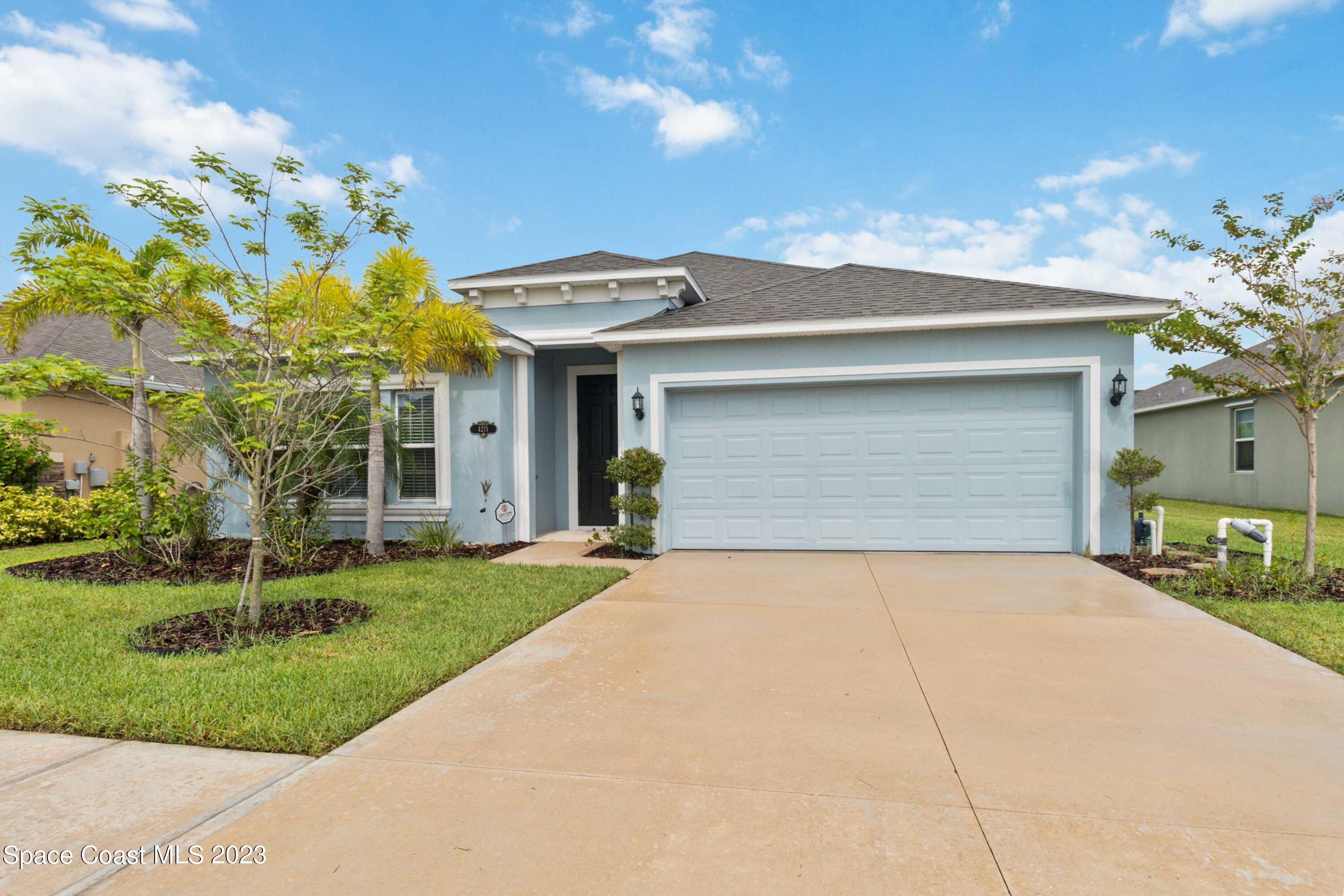4215 Ruthann Circle Melbourne, FL 32934 - Photo 3 of 41 a front view of a house with a yard and garage