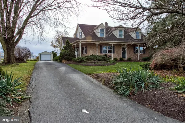 a front view of a house with a garden and trees