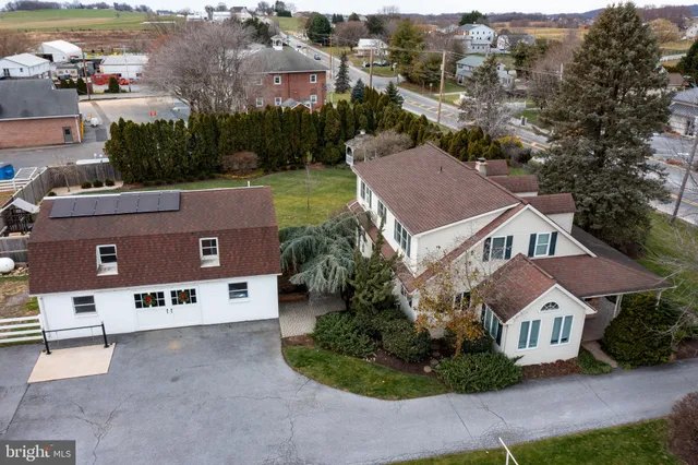 an aerial view of residential houses with outdoor space and parking