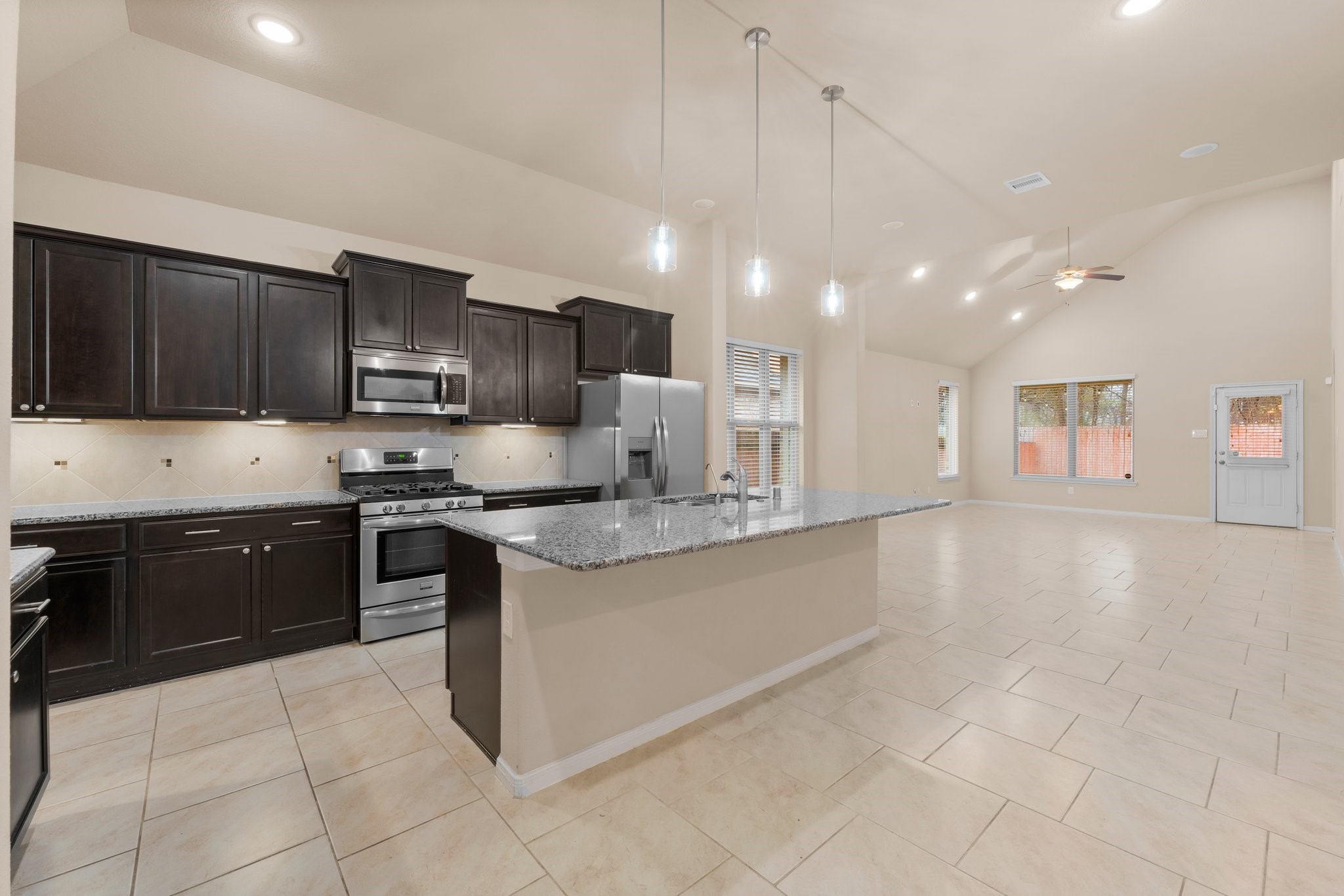 22314 Forbes Field Trail Spring, TX 77389 - Photo 10 of 46 Spacious kitchen with large island, dark cabinets, stainless steel appliances, and pendant lights, perfect for adding bar stools for extra seating.
