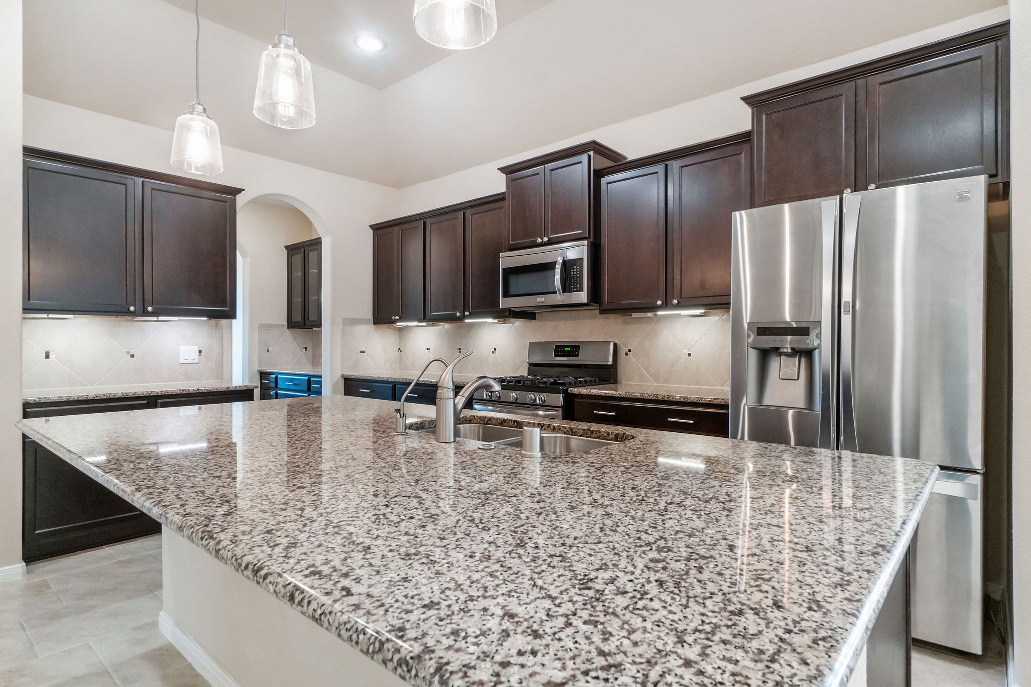 22314 Forbes Field Trail Spring, TX 77389 - Photo 11 of 46 Gleaming granite counters and rich wood cabinetry create and warm and inviting tone. The diagonal tile backsplash and undercabinet lighting complete the picture!