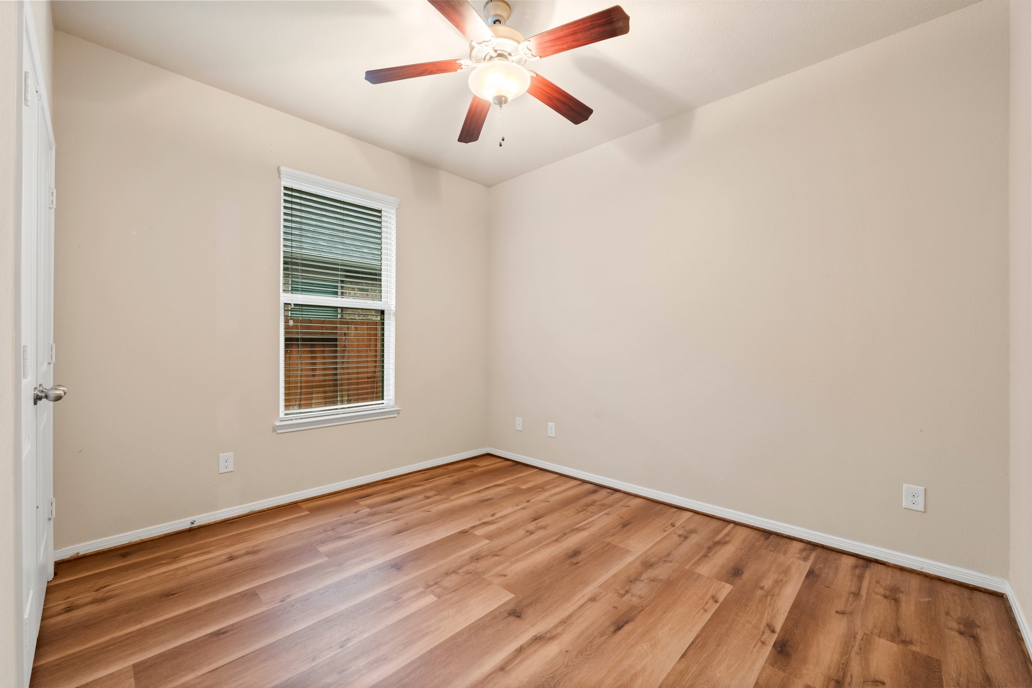22314 Forbes Field Trail Spring, TX 77389 - Photo 28 of 46 Secondary bedrooms are located in a separate wing from the Master. This bedroom includes new wood flooring in 2025, sunny window, wall closet, and ceiling fan with light.