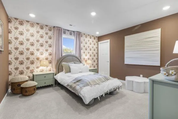 a bedroom with a baby bed a couch and dresser