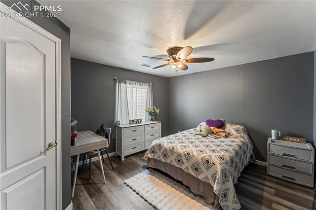 10158 Angeles Road Peyton, CO 80831 - Photo 31 of 43 Bedroom with ceiling fan, baseboards, dark wood-style floors, and visible vents