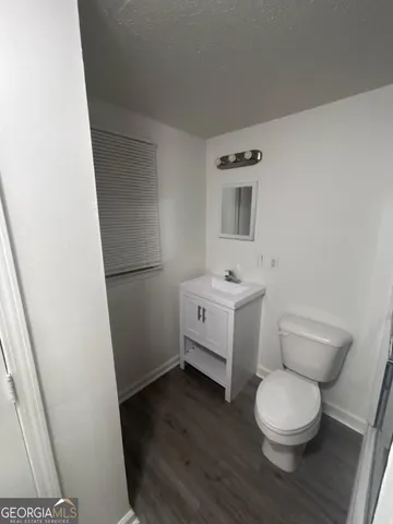 a bathroom with a toilet sink and a mirror