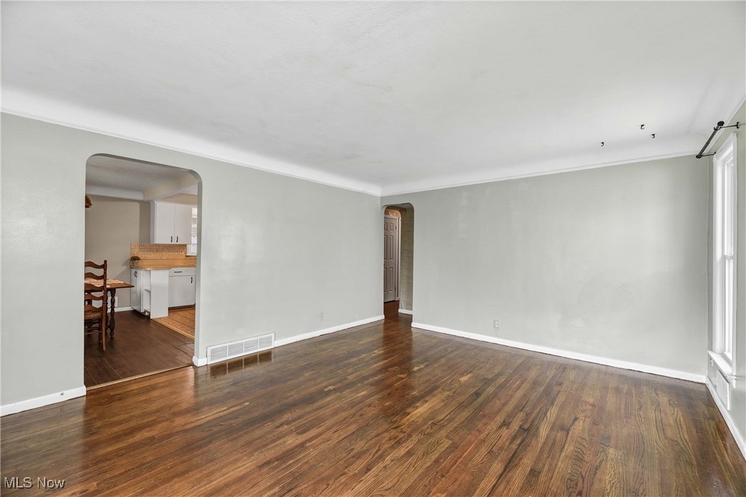 6506 Snow Road Parma, OH 44129 - Photo 10 of 25 Empty room featuring arched walkways and dark wood-type flooring