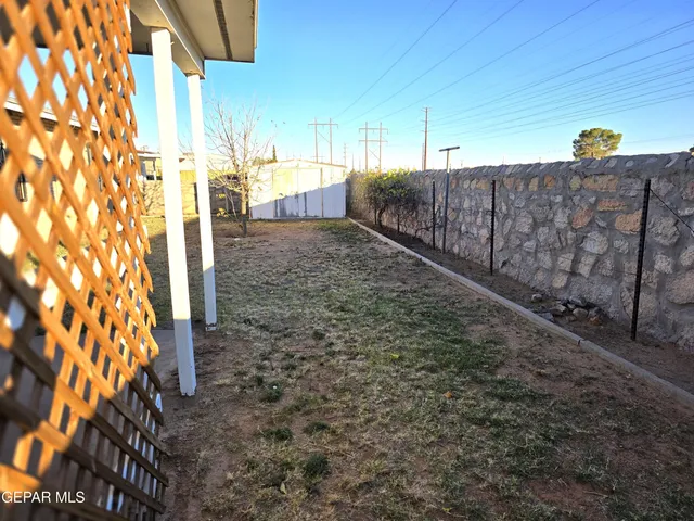 a view of a patio with table and chairs and wooden fence