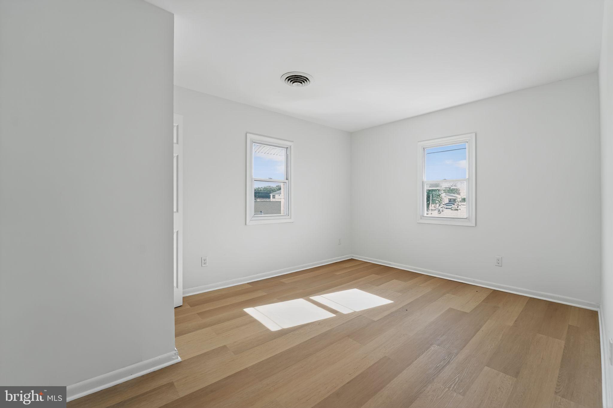 1008 Fuselage Avenue Baltimore, MD 21220 - Photo 13 of 30 an empty room with wooden floor and windows