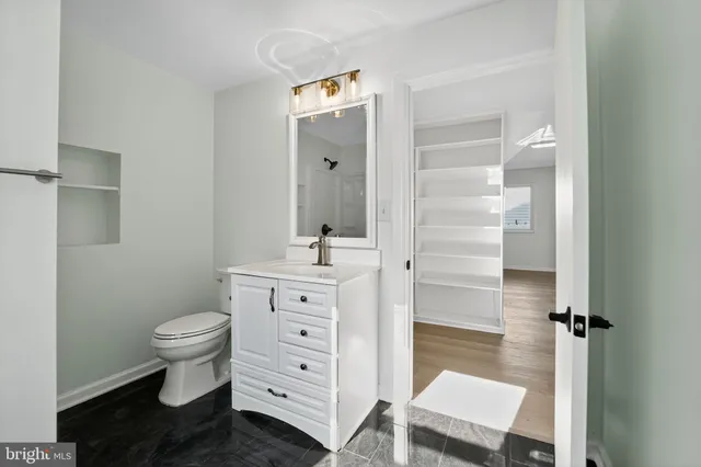 a bathroom with a sink a toilet a mirror and shower