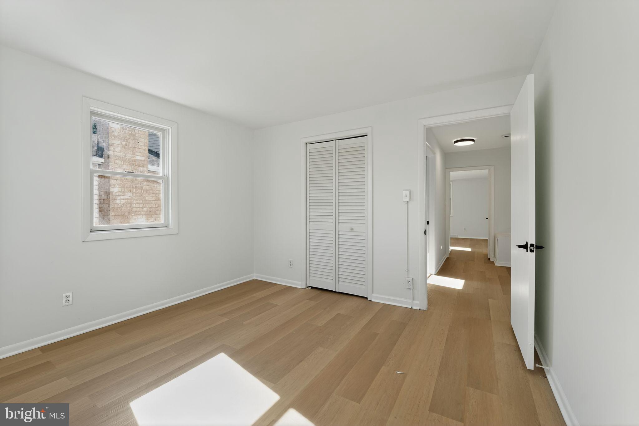 1008 Fuselage Avenue Baltimore, MD 21220 - Photo 21 of 30 an empty room with wooden floor and windows