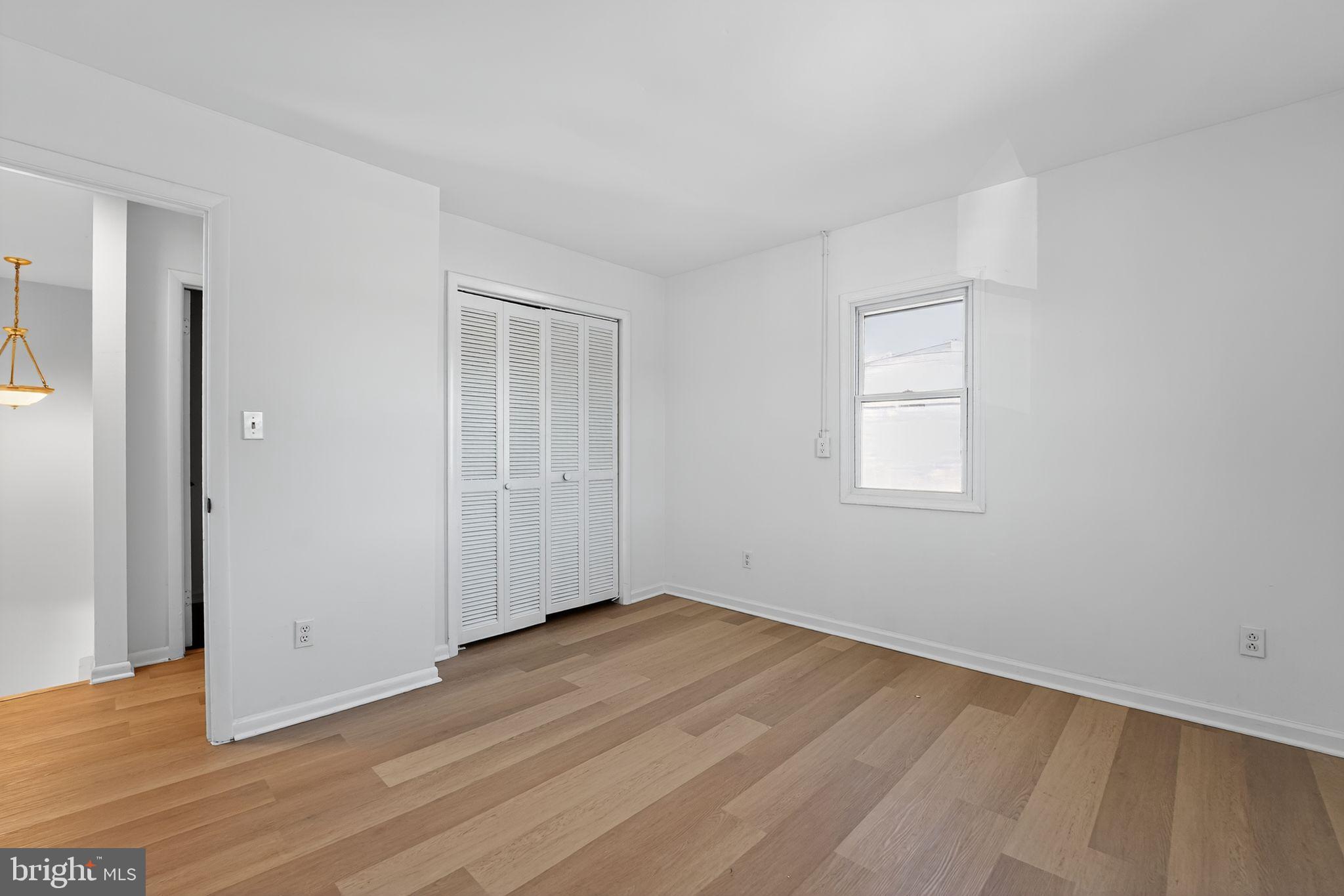 1008 Fuselage Avenue Baltimore, MD 21220 - Photo 22 of 30 an empty room with wooden floor and windows